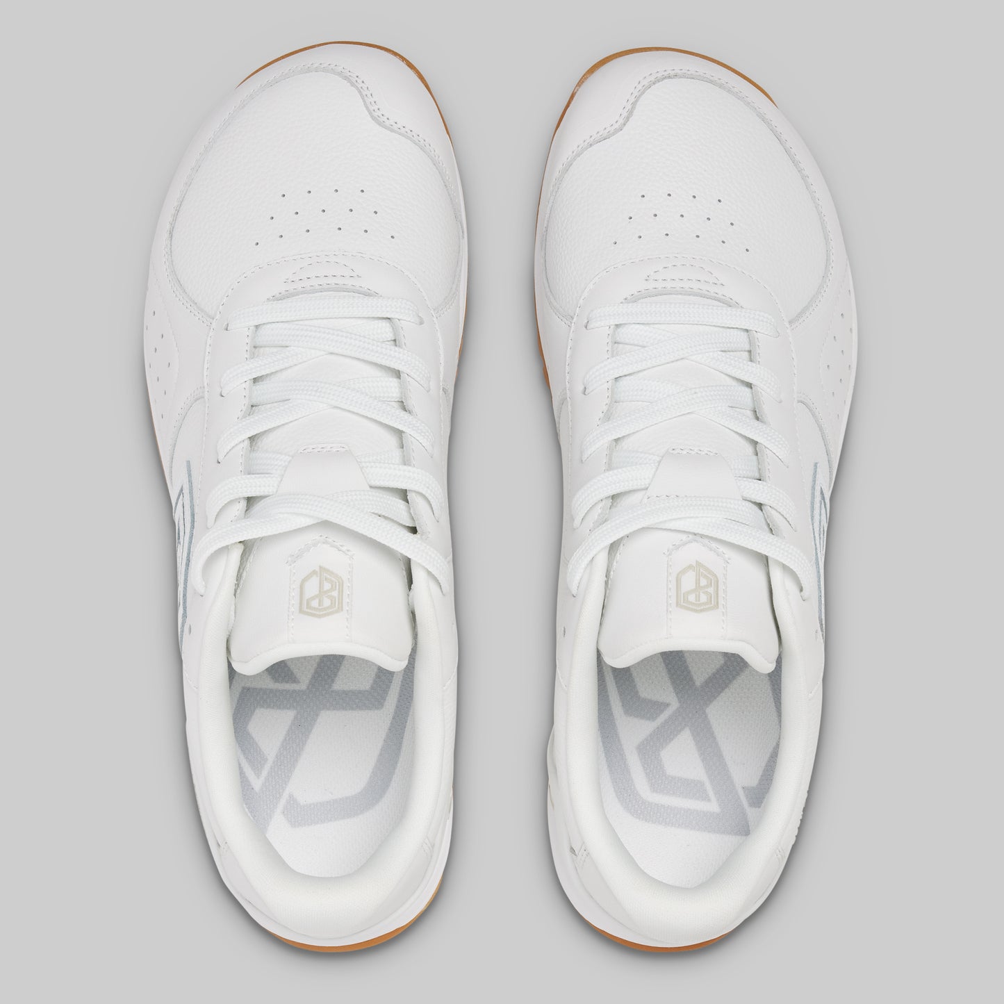 White sneakers with a brand logo on a gray background