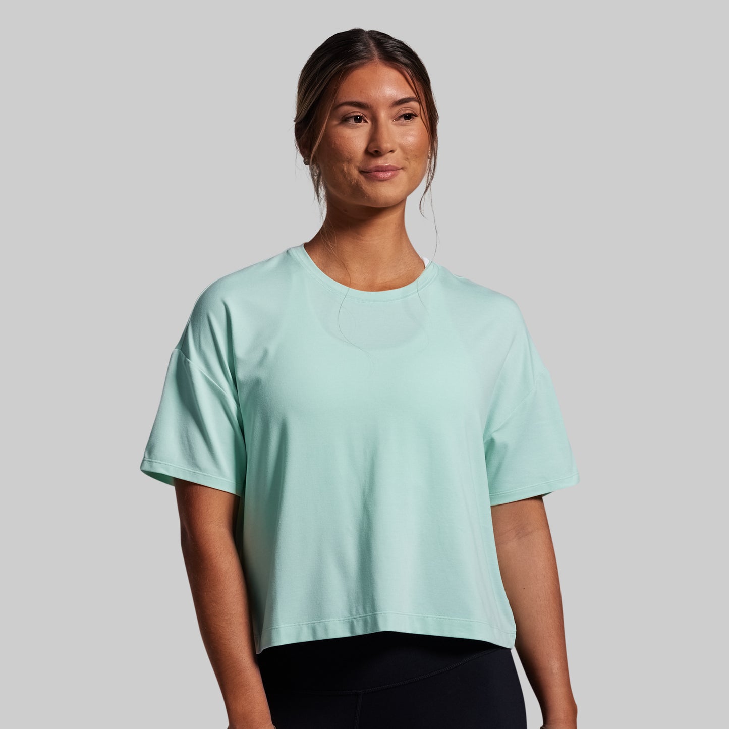 Woman wearing a light blue t-shirt against a plain background