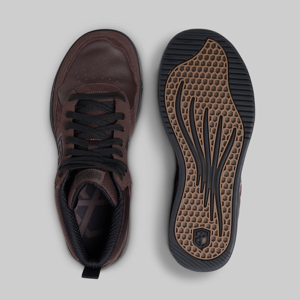 A pair of dark brown leather sneakers shown from a top-down view, with one shoe displaying the side profile and the other showing the textured brown and black outsole.
