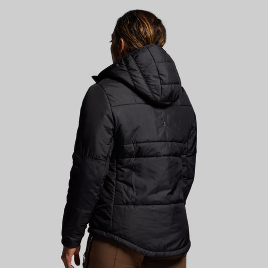 Person wearing a black puffer jacket on a gray background