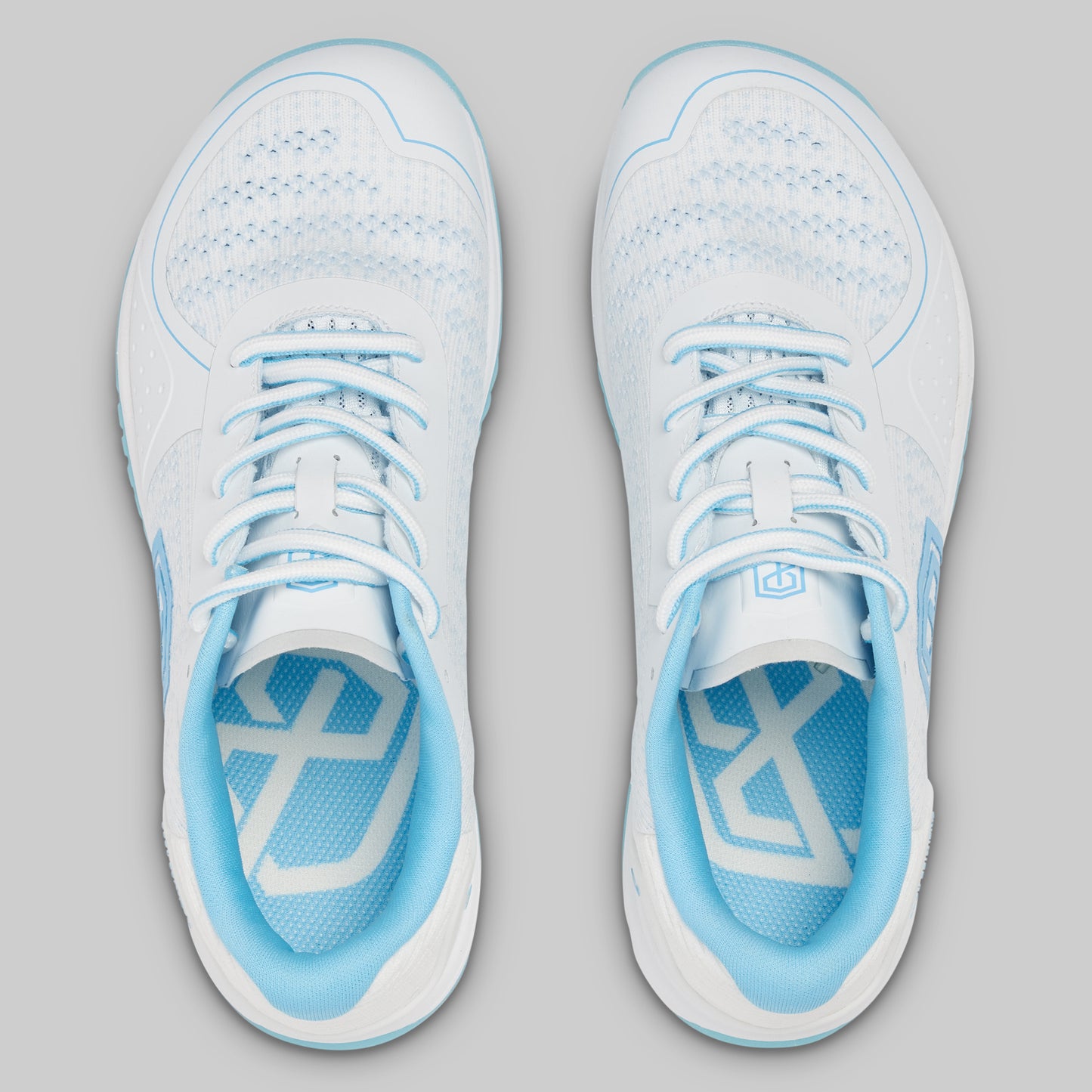 Pair of white and light blue athletic shoes on a gray background