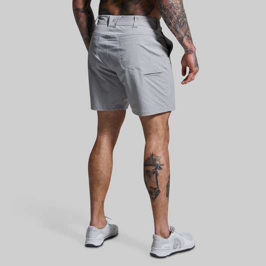 Person wearing light gray shorts on a plain background