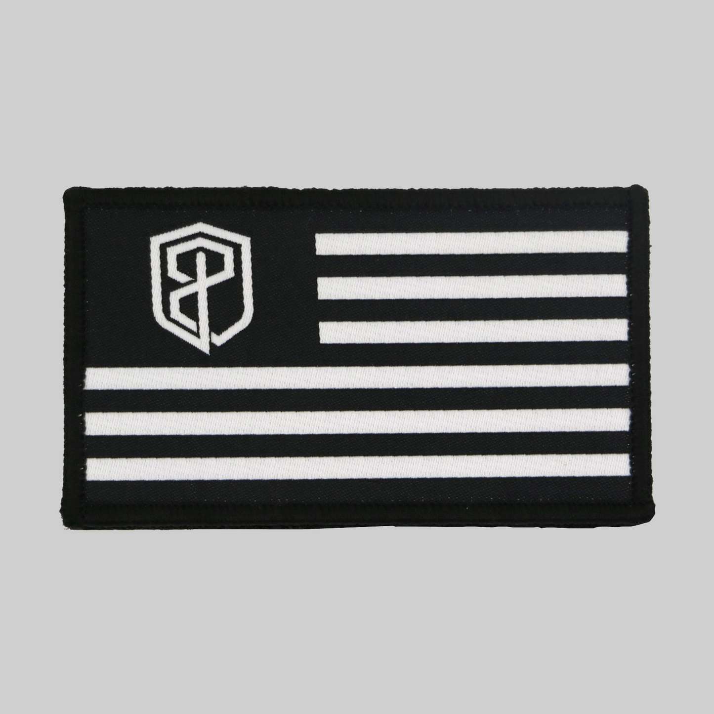 Black and white flag patch with a central emblem on a gray background