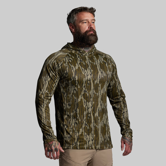 Man wearing a camouflage hoodie on a gray background
