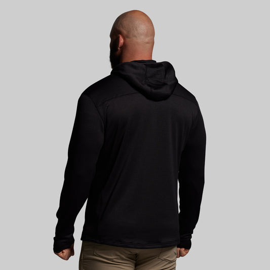 Person wearing a black hoodie from behind on a gray background