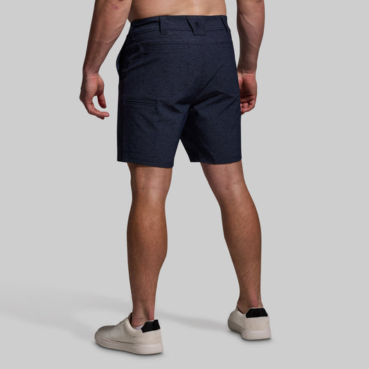 Person wearing navy shorts on a plain background