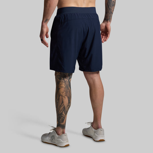 Person wearing navy shorts on a plain background
