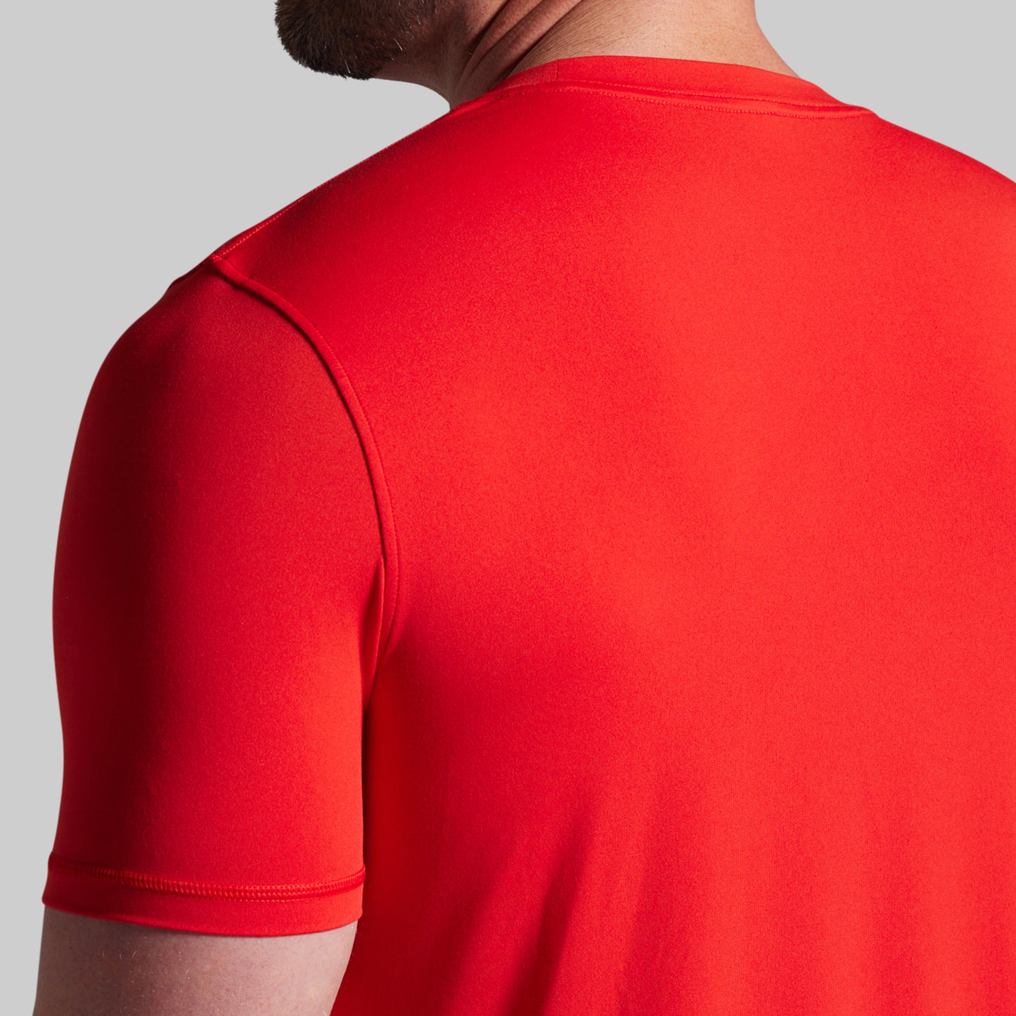 Red t-shirt worn by a person on a gray background