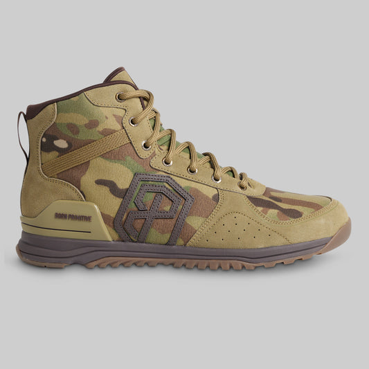 A high-top tactical boot in a tan and green camouflage pattern, featuring a prominent dark brown geometric logo on the side, a tan heel counter, and a brown and tan outsole, shown against a solid gray background.