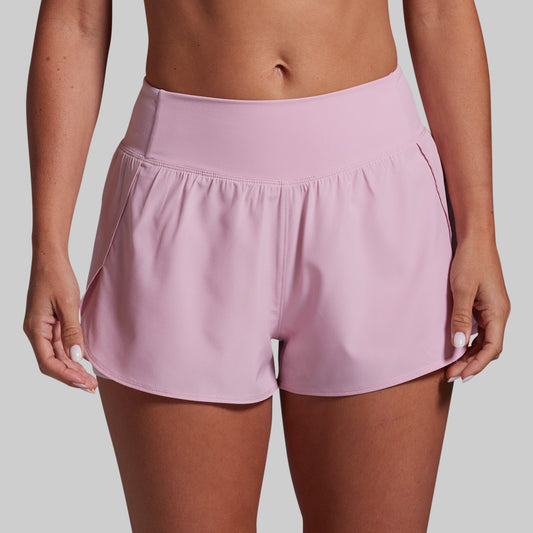 Pink athletic shorts worn by a person on a plain background