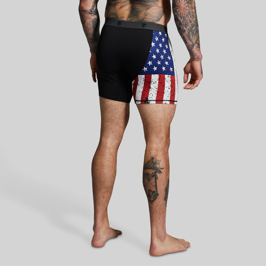 Man wearing black boxer briefs with American flag pattern on right leg.
