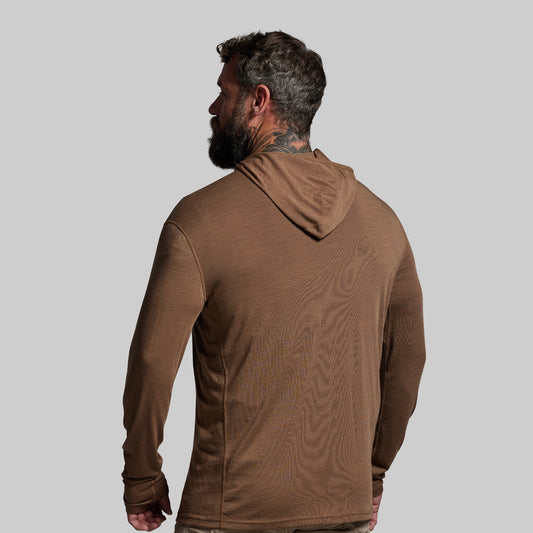 Man wearing a brown hoodie against a gray background