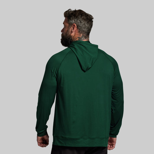 Man wearing a green hoodie from behind on a gray background