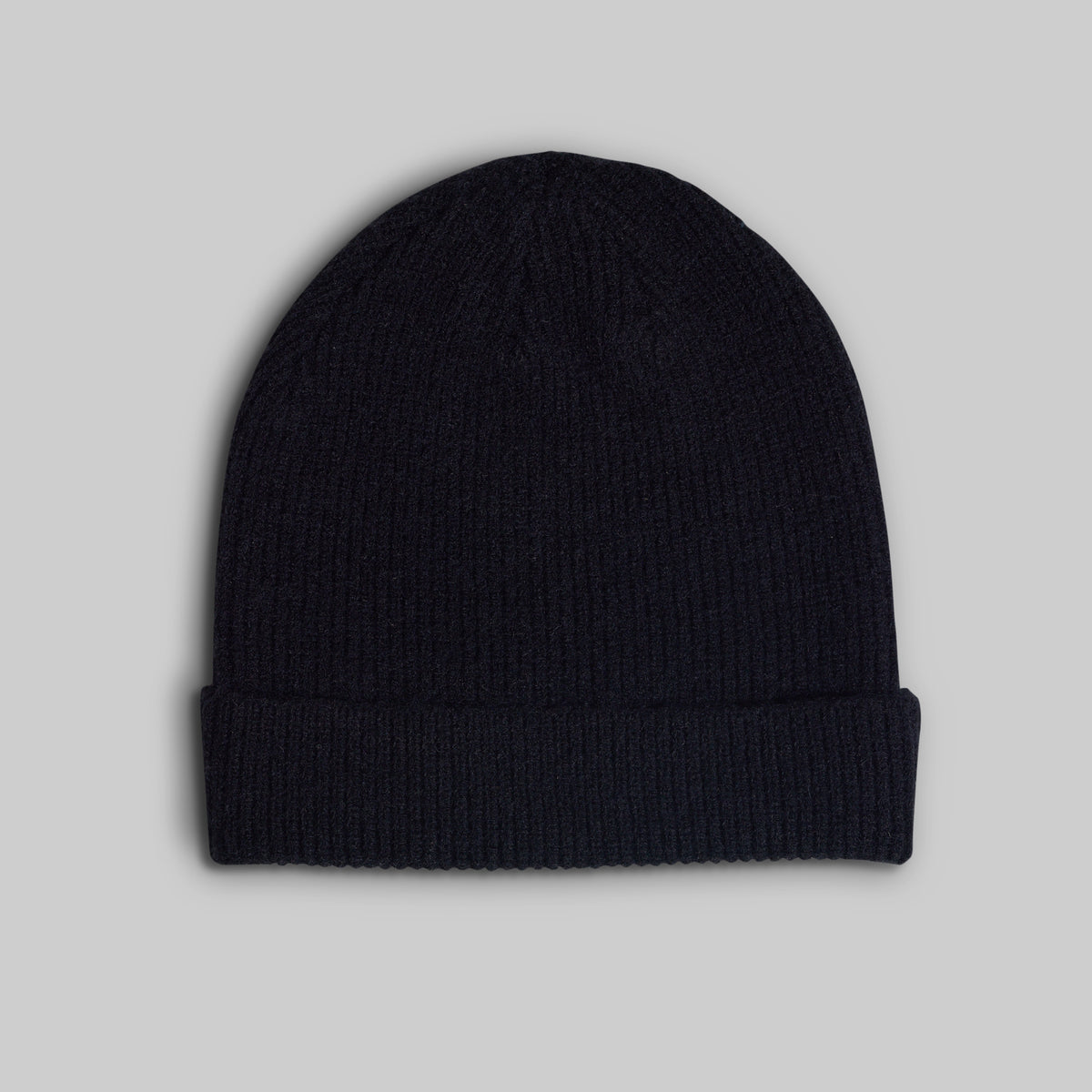 A dark navy blue ribbed knit beanie hat with a folded cuff, shown against a solid light gray background.