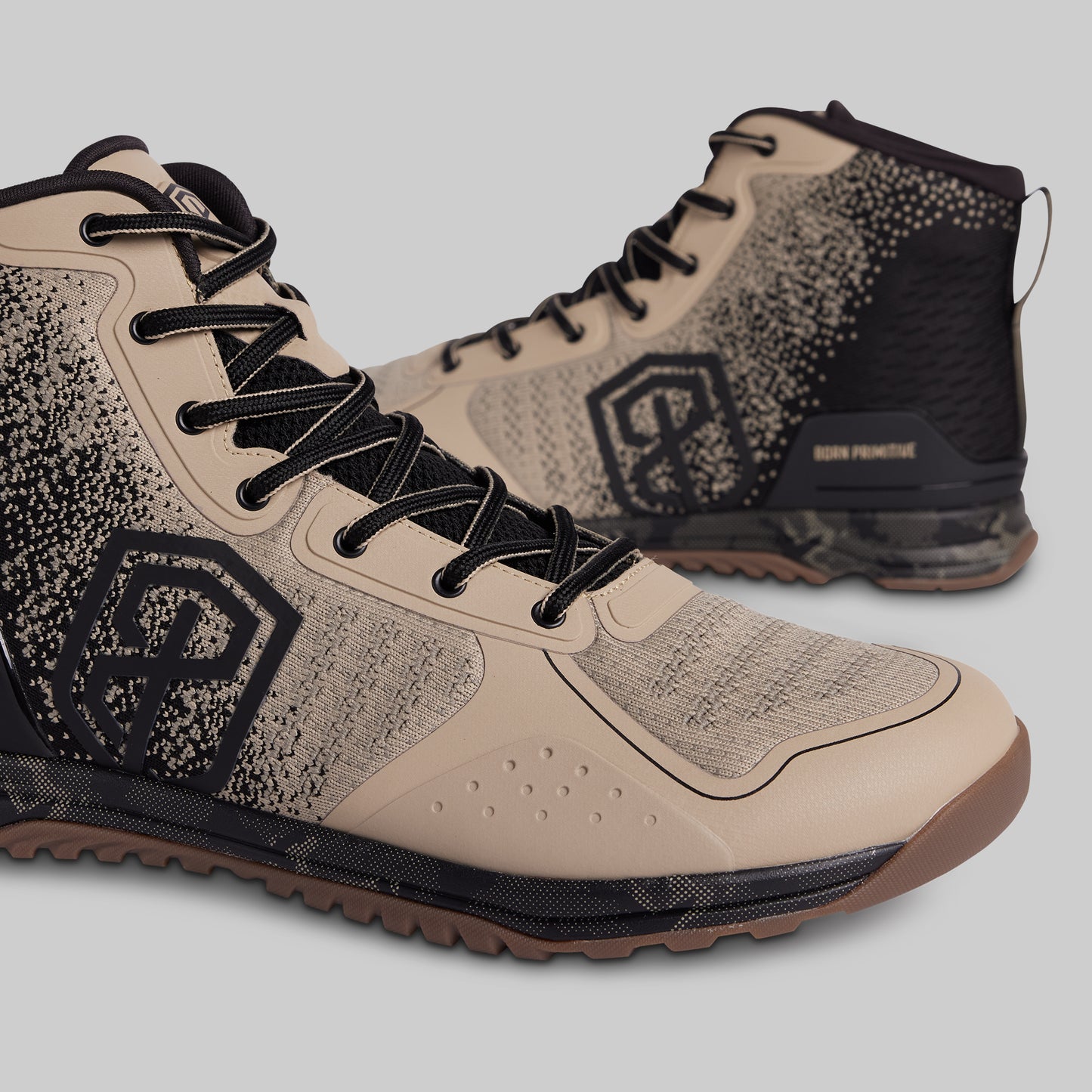 Beige and black high-top sneakers with a brand logo on a light gray background