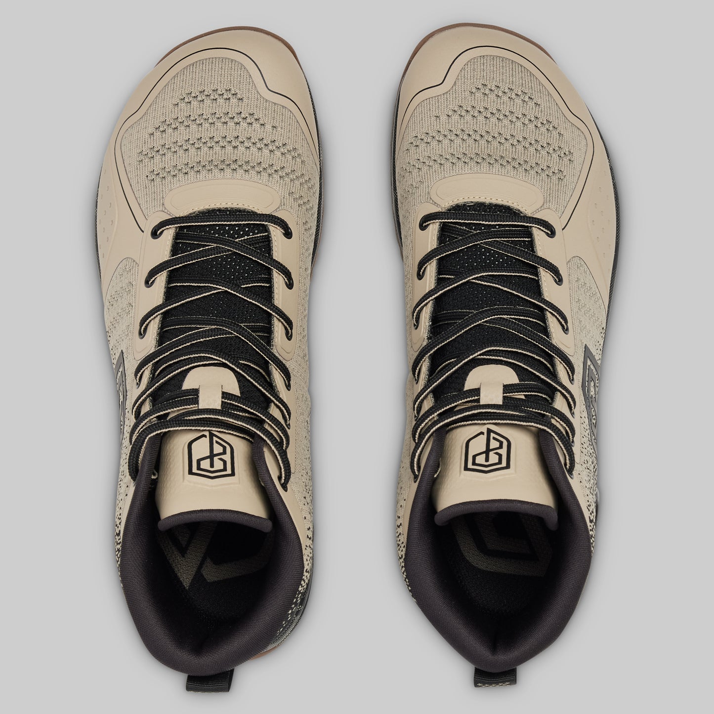 Pair of beige and black sneakers on a light gray background