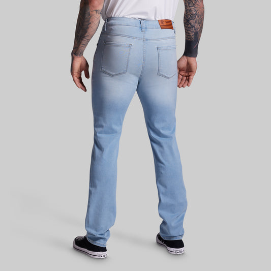 Light blue jeans worn by a person on a gray background