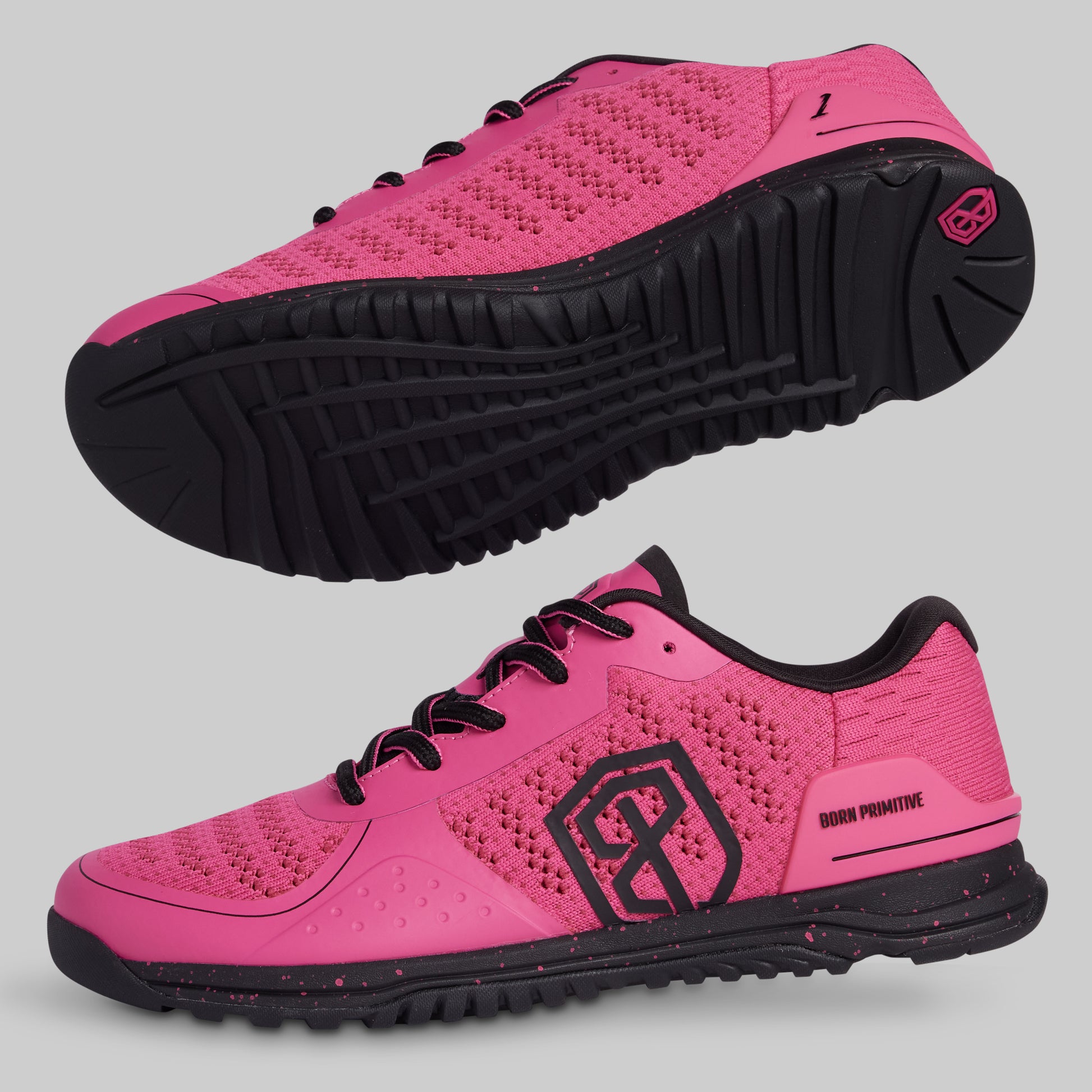 Pink athletic shoes with black soles on a gray background