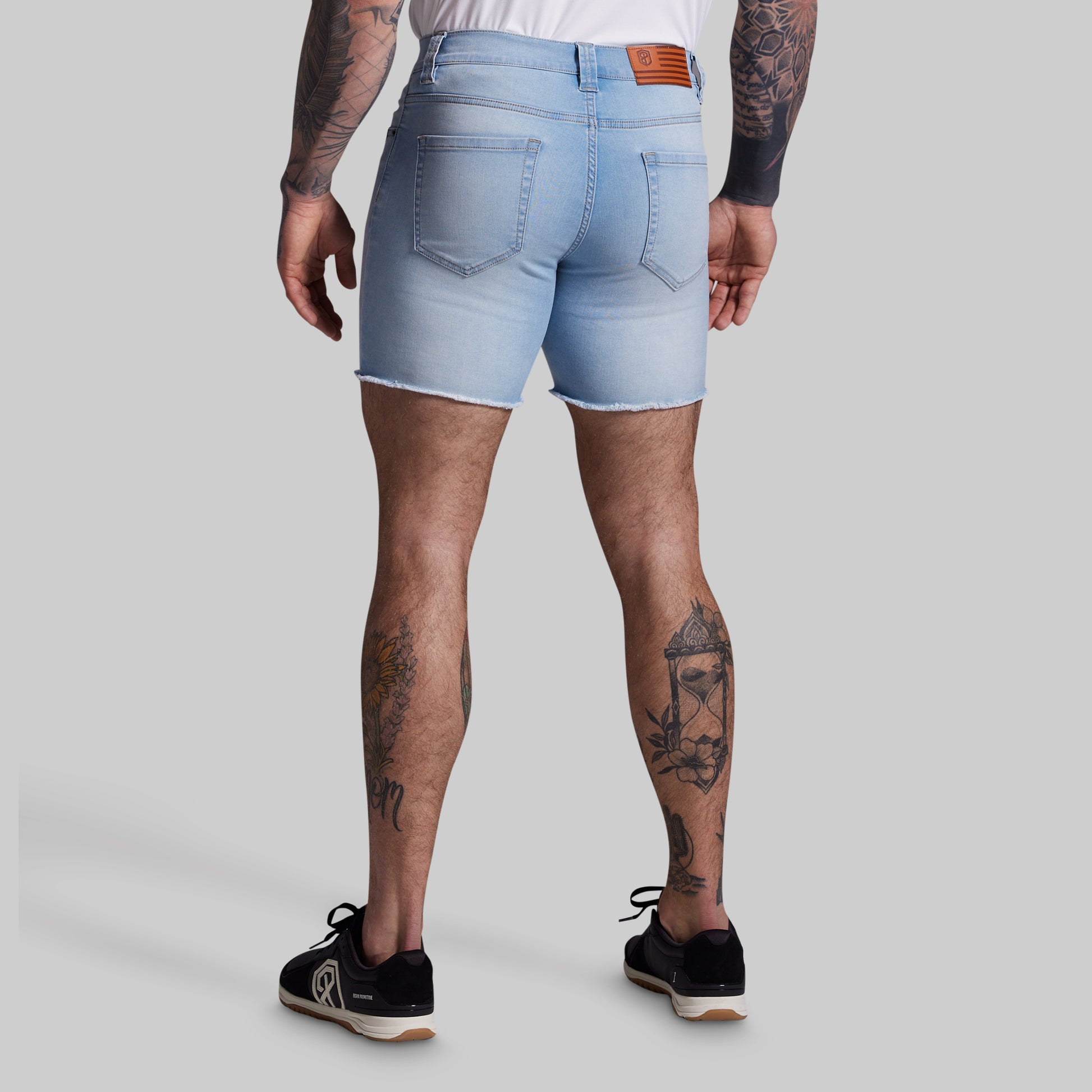 Person wearing light blue denim shorts on a plain background