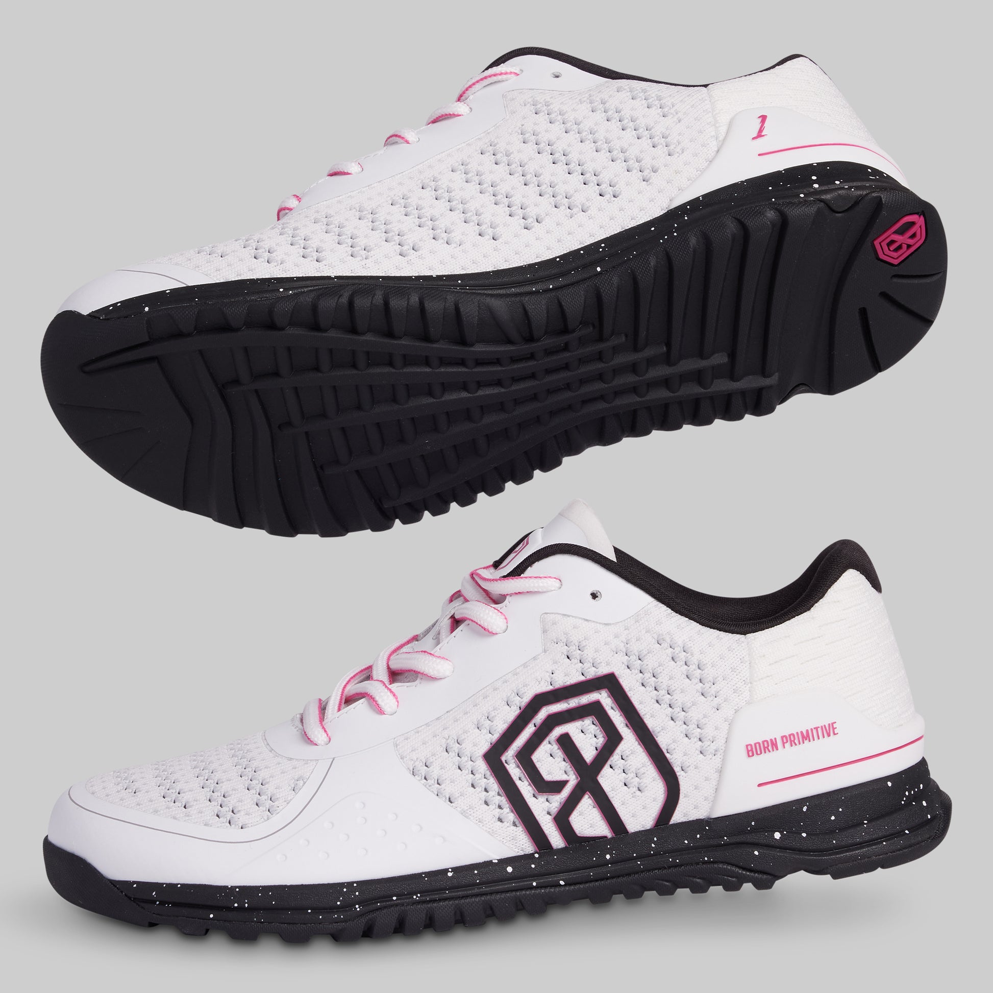 White athletic shoes with black soles and pink accents on a light gray background