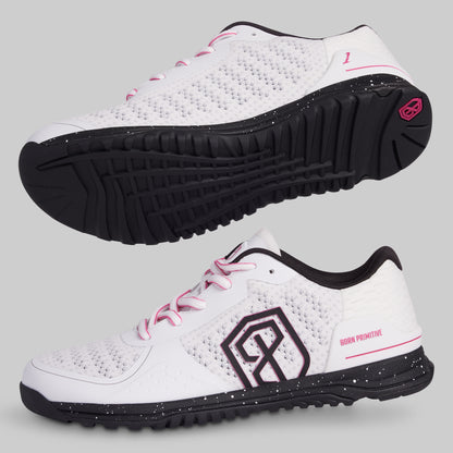 White athletic shoes with black soles and pink accents on a light gray background