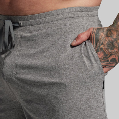 Person wearing gray shorts with a tattooed hand in pocket.