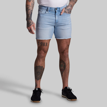 Person wearing light blue denim shorts on a plain background