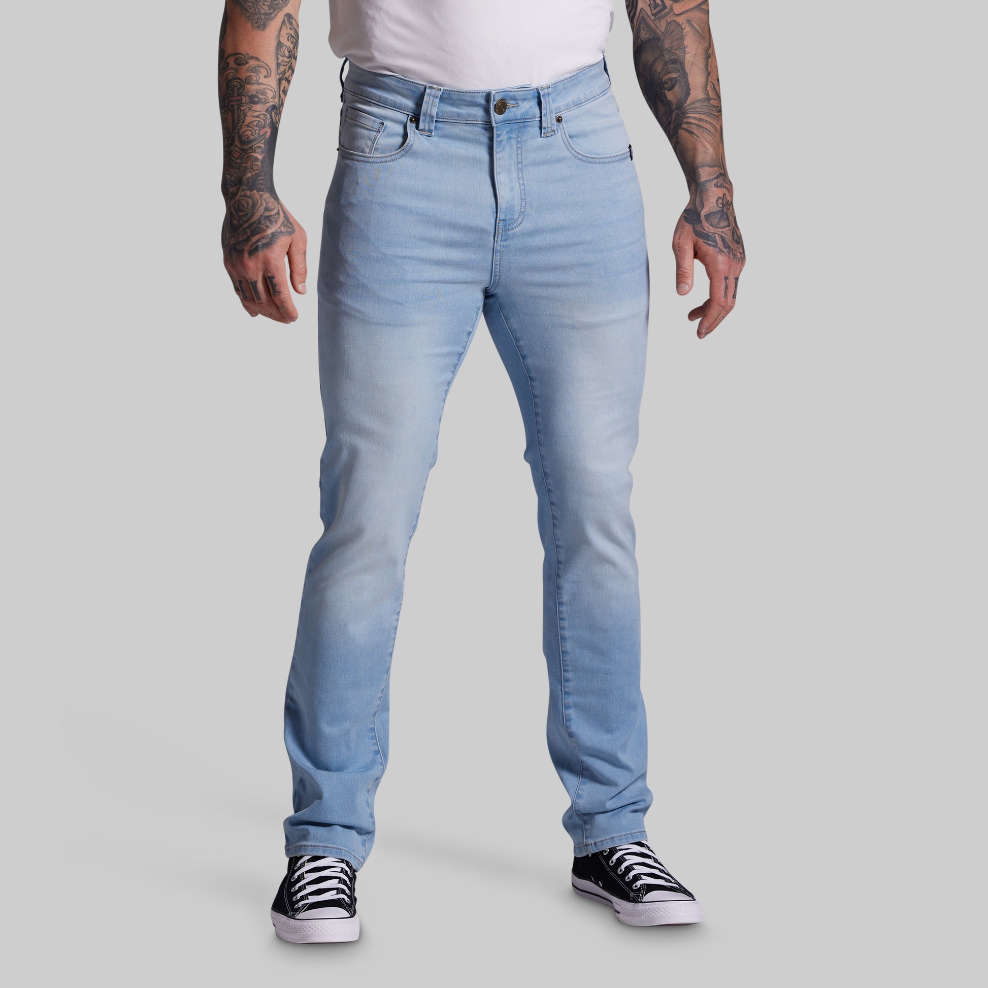 Person wearing light blue jeans on a gray background