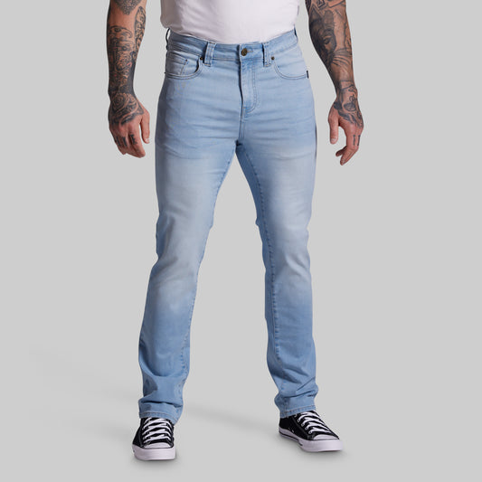 Person wearing light blue jeans on a gray background