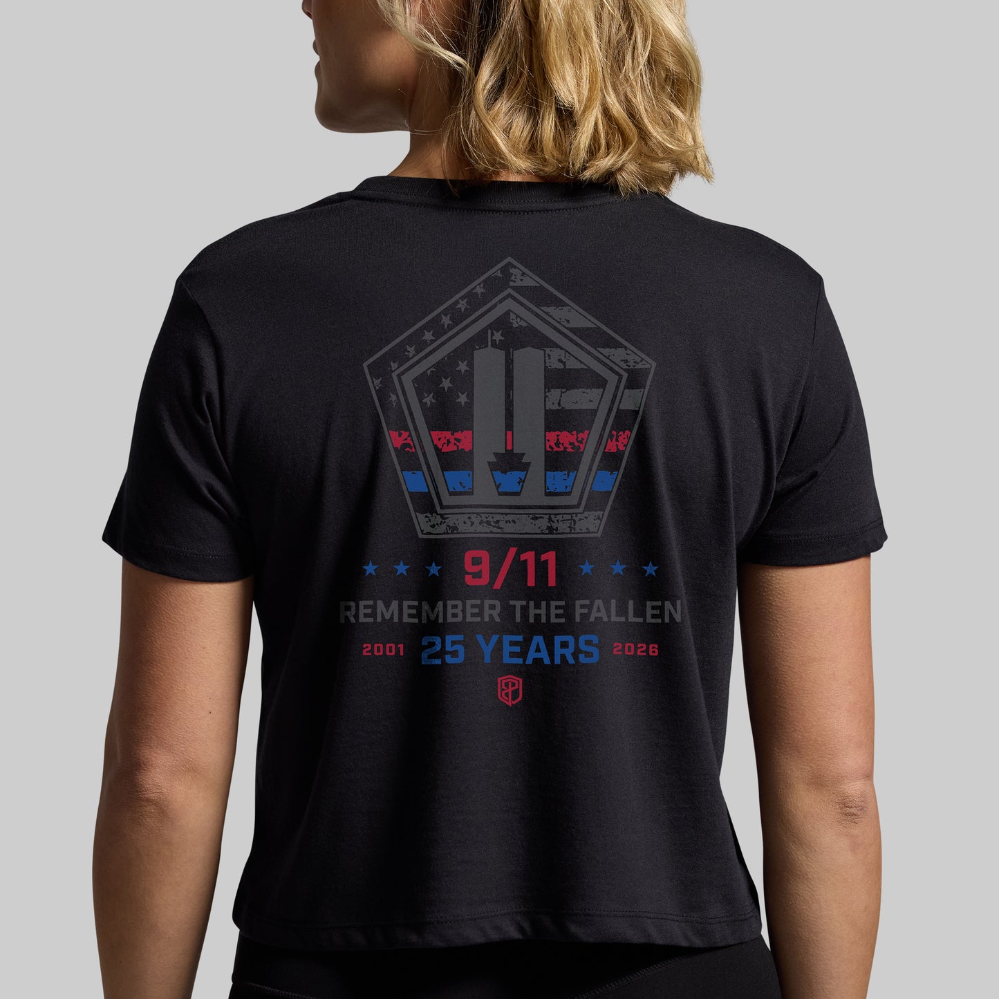 Woman wearing a black 9/11 25th Anniversary crop tee, back with Remember the Fallen 2001-2026 graphic