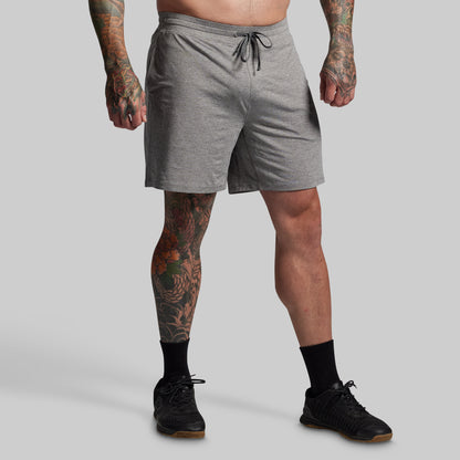 Person wearing gray shorts on a plain background