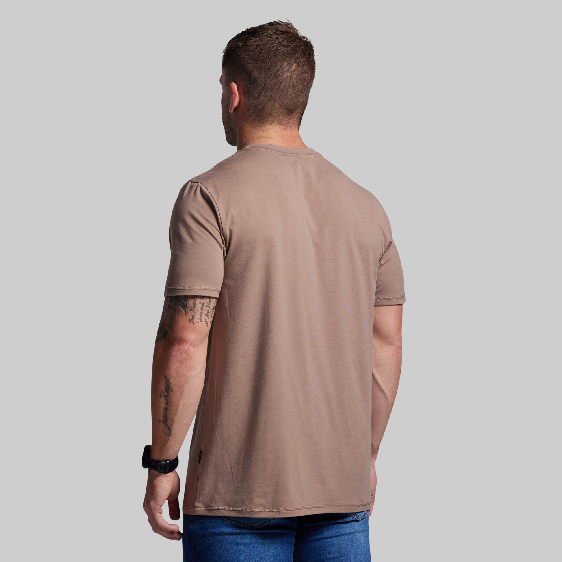 Man wearing a brown t-shirt on a gray background