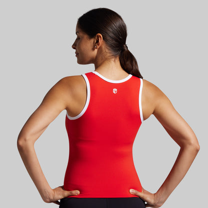 Woman wearing a red tank top with a logo on a gray background