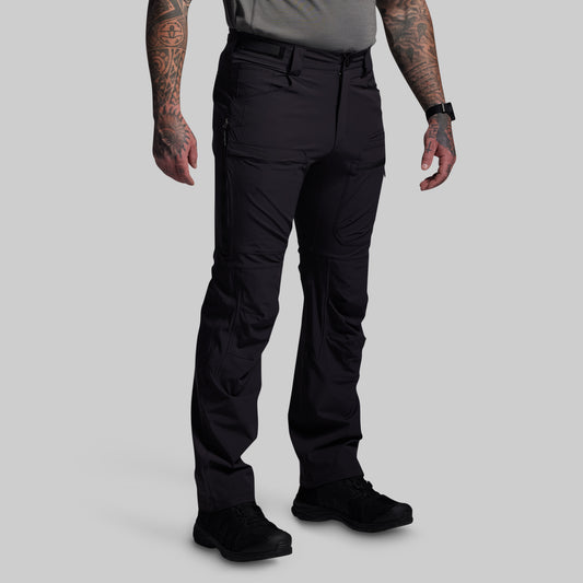 Person wearing black outdoor pants on a gray background
