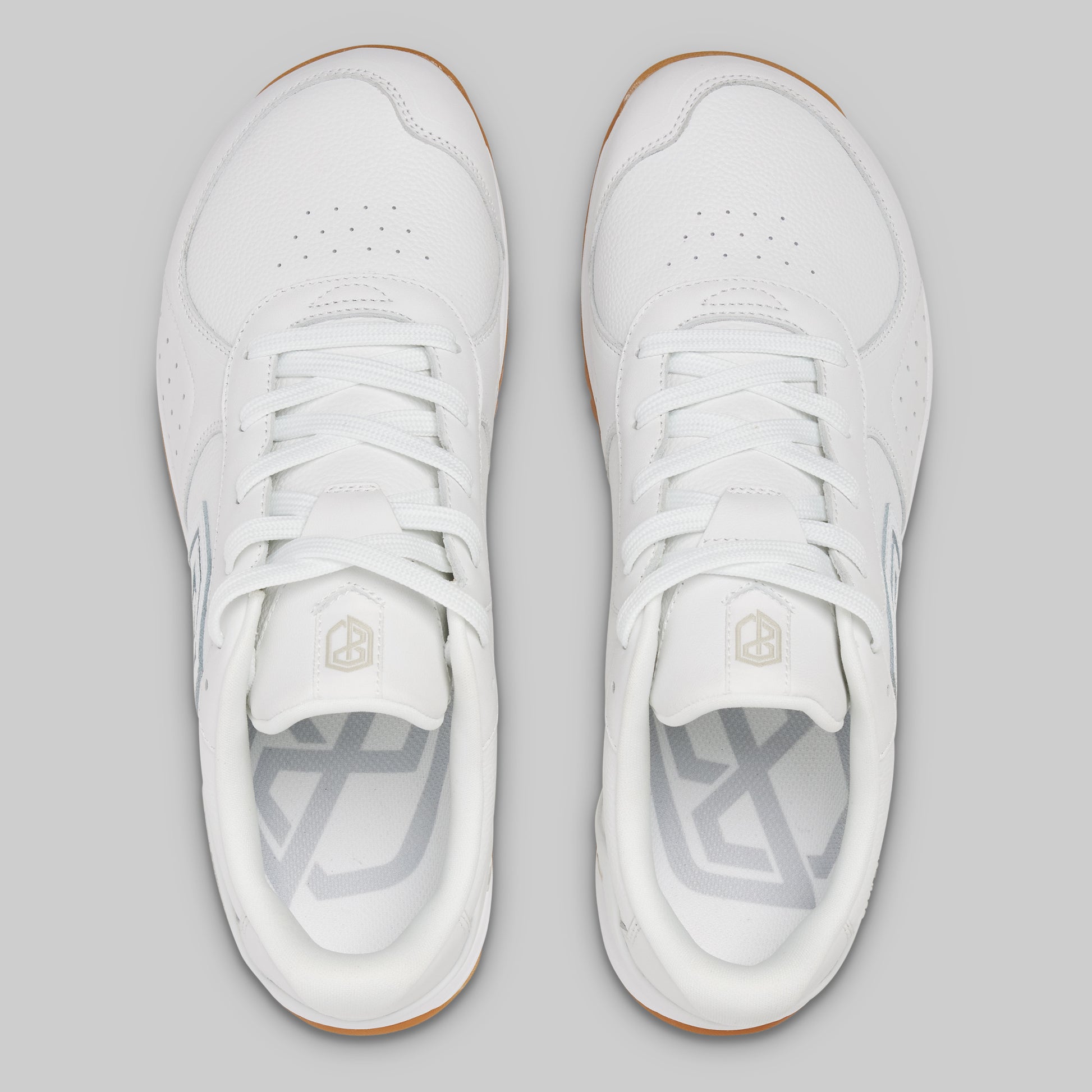 White sneakers with a brand logo on a gray background