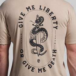 Beige t-shirt with black snake and sword graphic and text on a plain background