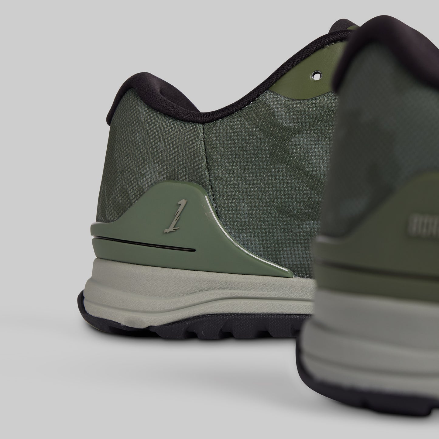 Green athletic shoe with brand logo on a light gray background