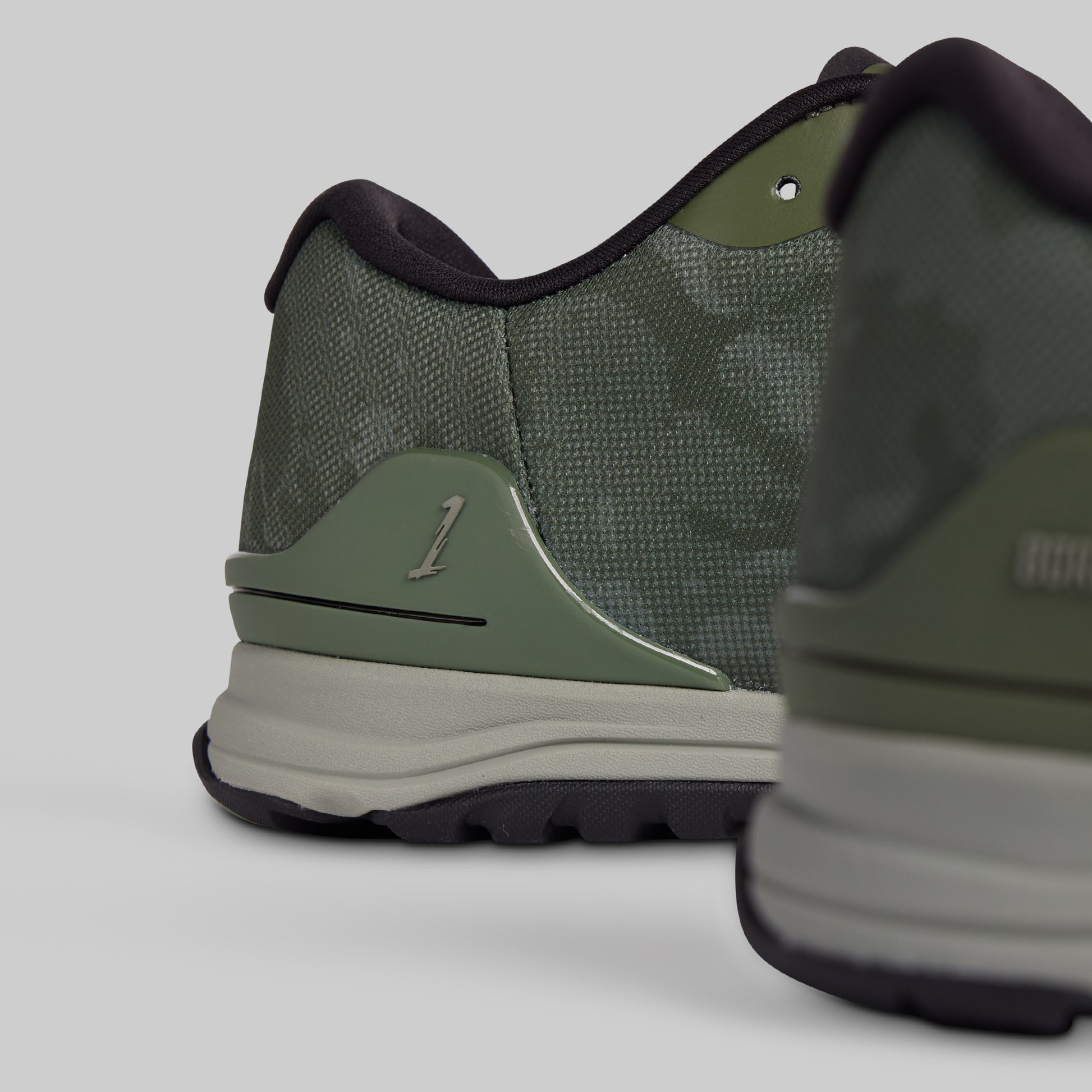 Green athletic shoe with brand logo on a light gray background
