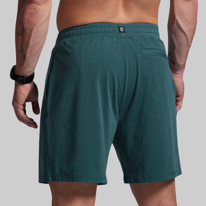 Teal shorts worn by a person on a plain background