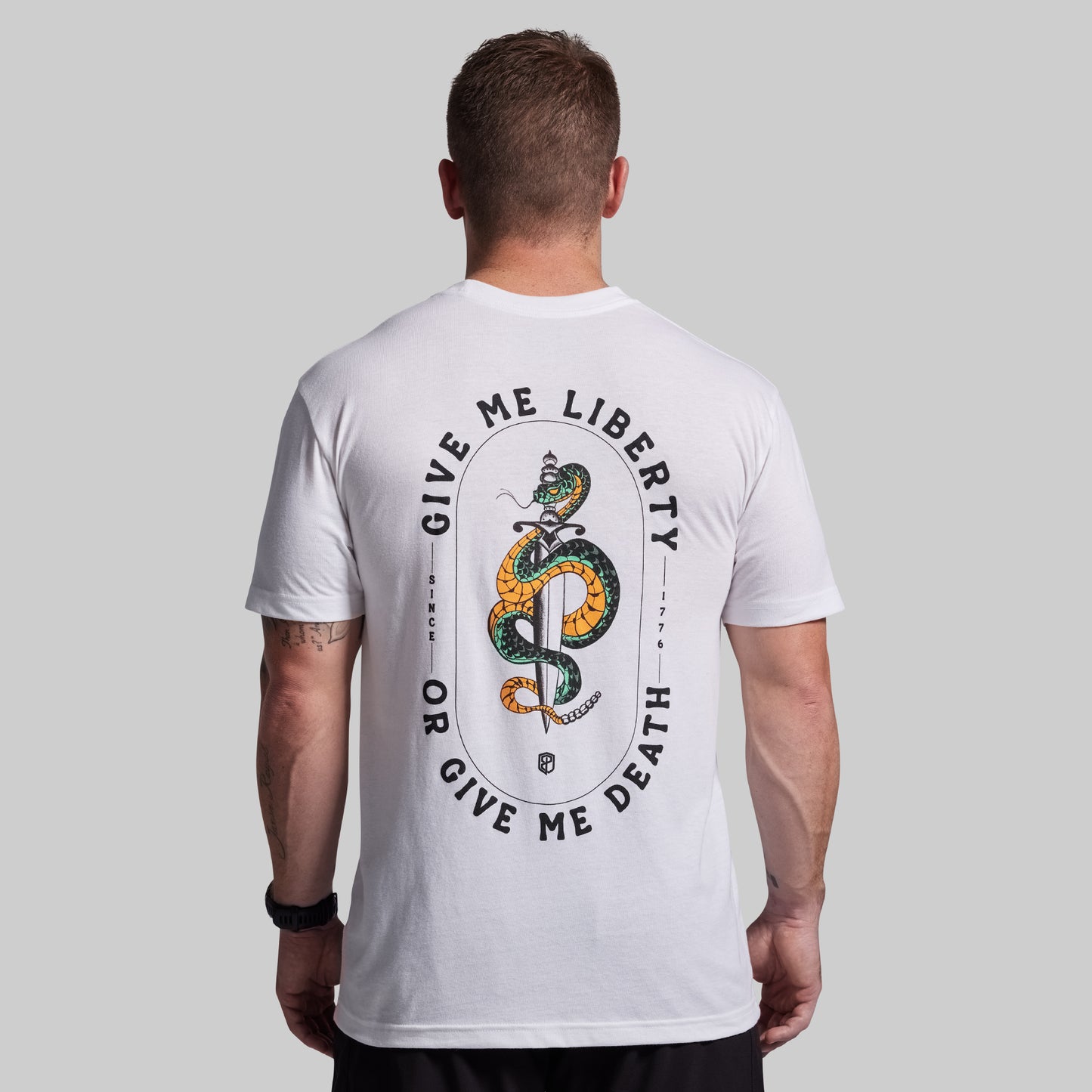 Person wearing a white t-shirt with a snake graphic and text on the back against a gray background