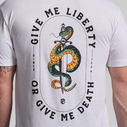 White t-shirt with snake and sword graphic and text 'Give Me Liberty or Give Me Death' on a plain background