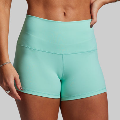 Teal athletic shorts worn by a person on a plain background
