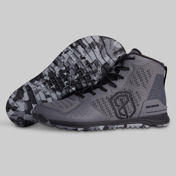 Gray athletic shoes with camouflage sole on a light gray background