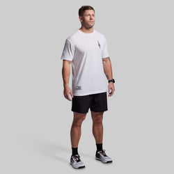 Man wearing a white t-shirt and black shorts on a gray background