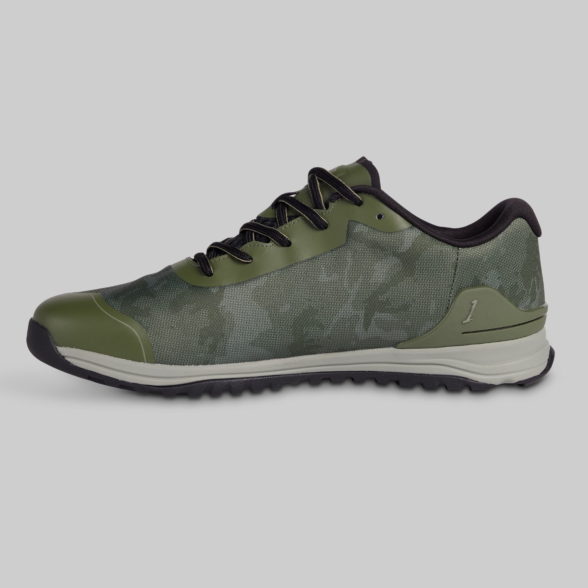 Green athletic shoe with black laces on a gray background