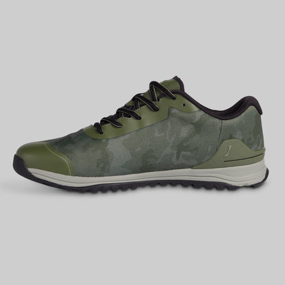Green athletic shoe with black laces on a gray background