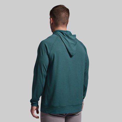 Man wearing a teal hoodie from behind on a gray background