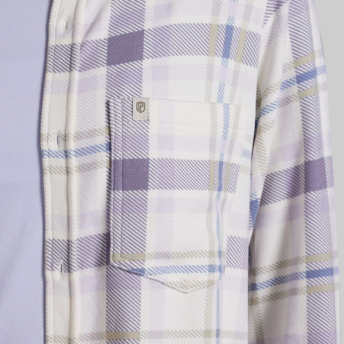 Close-up of a plaid button-up shirt with a chest pocket, featuring a white base with lavender, light blue, and beige stripes.