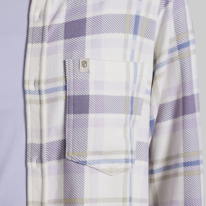 Close-up of a plaid button-up shirt with a chest pocket, featuring a white base with lavender, light blue, and beige stripes.