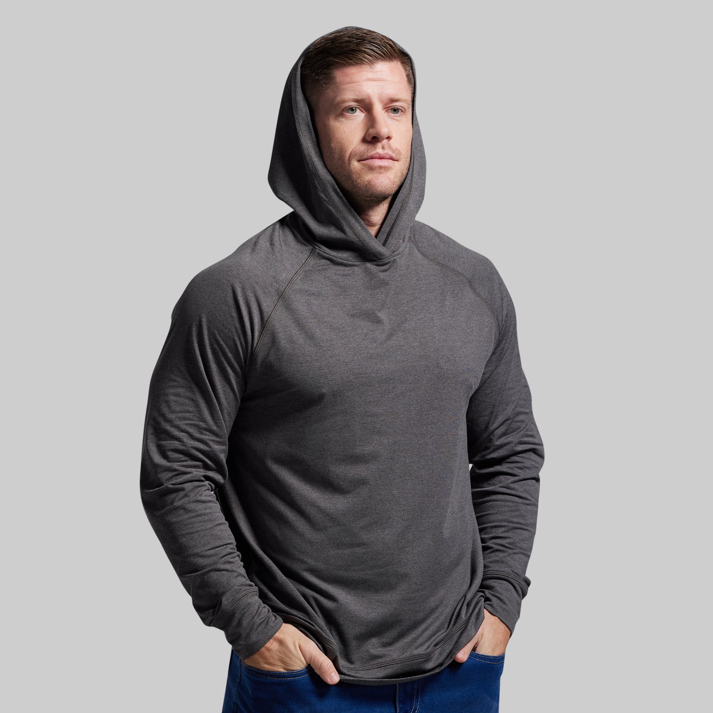 Man wearing a gray hoodie against a plain background